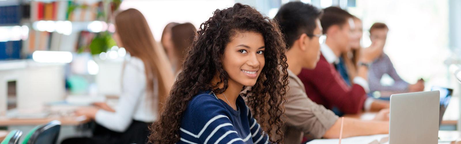 Female student in class smiling at the camera